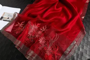 Red silk embroidered scarf detail view, featuring exquisite floral embroidery and metallic edges.