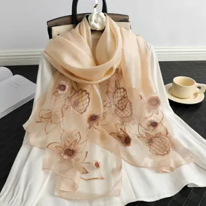 Detailed view of luxury champagne silk embroidered scarf featuring elegant floral patterns.