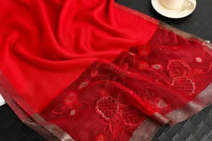 Red silk wool embroidered scarf detail, elegant floral pattern and shiny edge design.