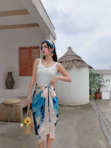 Detail view of a summer beachwear set featuring a white tank top and blue tie-dye sarong.