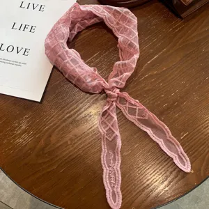 Pink lace hair band with elegant grid pattern and chic knot, stylish women's hair accessory.