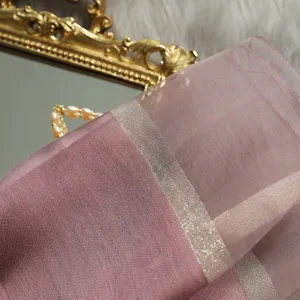 Primer plano detalle de bufanda rosa transparente con raya plateada metálica textura