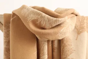 Close-up view of a cozy feather printed cashmere winter scarf, soft warm texture detail.