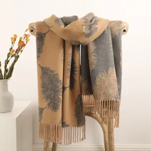 Detailed view of a cozy winter cashmere scarf featuring elegant feather patterns and fringe hem.