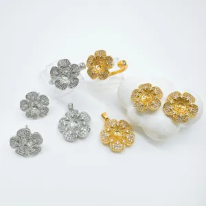 Nahaufnahme von DIY-Blumen-Schmuckkomponenten mit goldenen und silbernen Anhängern und Ohrringen.