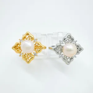 Detail shot of delicate filigree lace quatrefoil rings with pearl and glittering cubic zirconia.