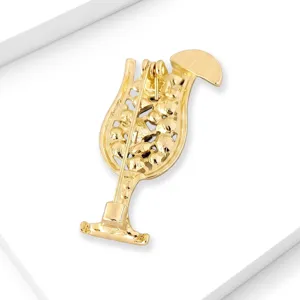 Detailed view of the gold-colored cocktail glass brooch showing secure pin clasp backing.
