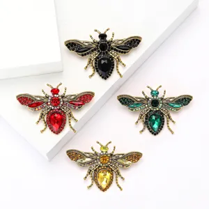 Set of four vintage crystal rhinestone bee insect brooches in assorted colors for apparel.