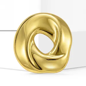 Golden stainless steel twisted round ring brooch detail close up view accessory items