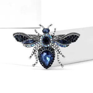 Detailed shot of sparkling blue crystal bee brooch, vintage silver alloy craftsmanship.