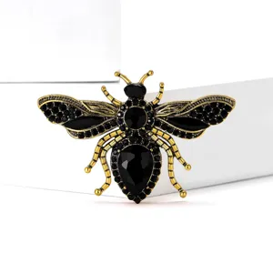 Detailed shot of exquisite gold alloy black rhinestone bee brooch, delicate suit accessory.