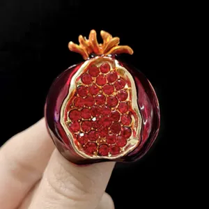 Exquisita broche de granada con pedreria roja y acabado dorado, elegante accesorio de ropa