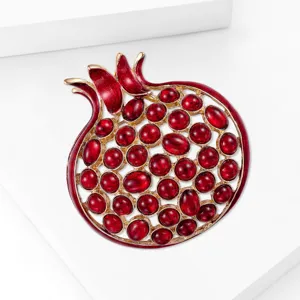 Broche de granada con esmalte rojo e incrustaciones de piedras para chaqueta elegante.