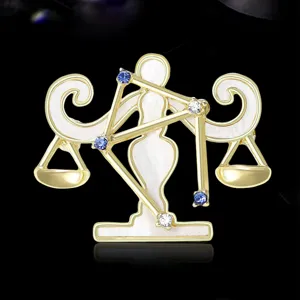 Elegante spilla con segno zodiacale Bilancia dorata con smalto bianco e cristalli scintillanti.