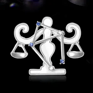 Dettaglio della spilla segno zodiacale Bilancia con cristalli blu e trasparenti.