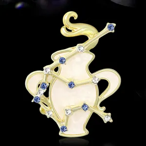Dettaglio spilla segno zodiacale Acquario, metallo dorato con cristalli blu e bianchi.