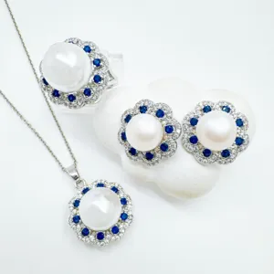 Perlen Schmuckset mit floraler Halskette, Ohrringen und Ring mit blauen und weißen Steinen.