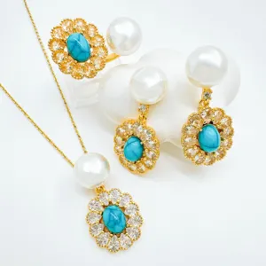 Detailaufnahme von Vintage Perle und Türkis Blume Anhänger Halskette Ohrringe Schmuck Set.