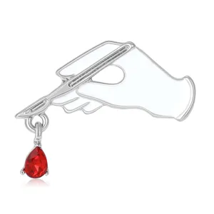 Creative alloy enamel scalpel brooch with red crystal teardrop, perfect medical fashion pin.