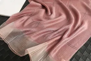 Detail view of luxury pink silk wool plaid scarf featuring elegant metallic gold stripes.