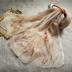 Exquisite embroidered silk scarf detail, elegant floral pattern, soft luxury shawl accessory.