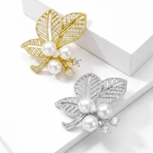 Detalle en primer plano de la exquisita broche de perlas de hojas y circón en oro y plata.