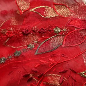 Close-up of red silk scarf with gold embroidery, traditional Chinese style luxury shawl detail.