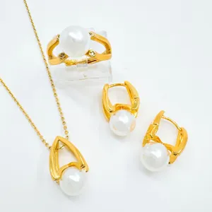 Detailed view of fashionable gold-plated pearl jewelry set including necklace, ring and earrings.