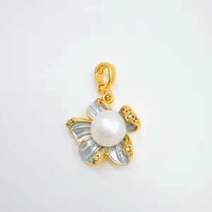Close up of pearl flower pendant with shiny crystal and gold tone details for necklace.