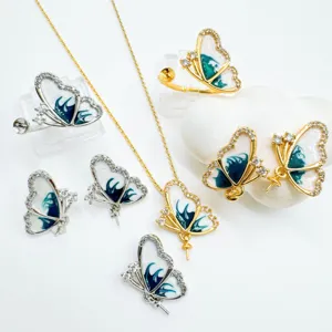 Detailed view of luxury butterfly jewelry set with green enamel, crystals, and gold chain.