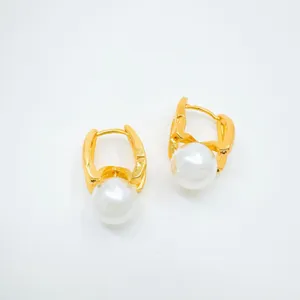 Gold plated pearl earrings detail closeup, elegant drop fashion jewelry accessory.