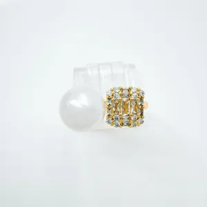 Close-up of asymmetric pearl and crystal cluster ring with gold setting, elegant detail shot.