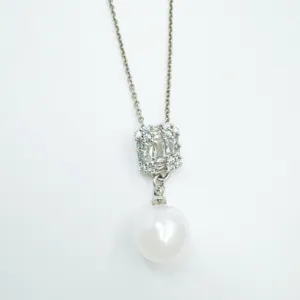 Detail view of elegant pearl and zirconia cluster pendant necklace close up display.