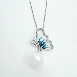 Exquisite butterfly pearl pendant detail shot, silver tone necklace with enamel and zirconia.