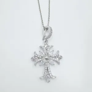 Silberfarbene Zirkon Kreuz Anhänger Halskette Detail, glitzernde Kristalle an feiner Kette.