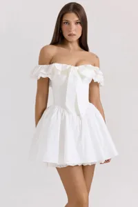 Robe mini blanche épaules dénudées avec nœud devant, bordure en dentelle et taille cintrée.