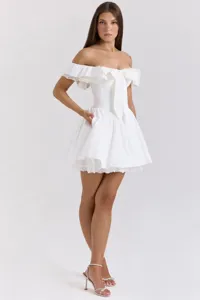 Robe courte blanche à épaules dénudées avec bordure en dentelle, volants et grand nœud.