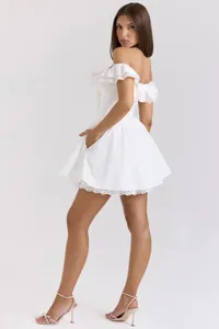 Détail de la mini-robe blanche hors de l'épaule avec bordure en dentelle délicate et poches.