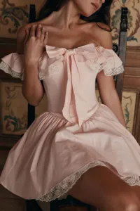 Élégante robe vintage française rose épaules dénudées avec nœud et détails en dentelle.