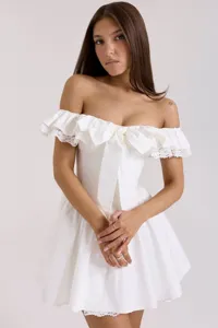 Gros plan détaillé de la robe courte blanche épaules dénudées avec nœud et dentelle.