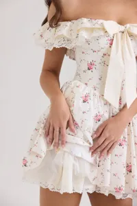 Gros plan détaillé de la robe vintage à fleurs hors épaule avec nœud et fine dentelle.