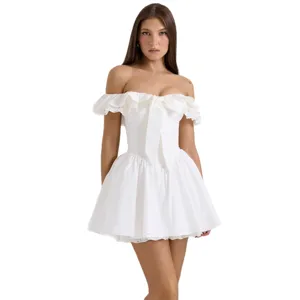Élégante robe mini blanche hors épaule avec volants, nœud avant et détails en dentelle.