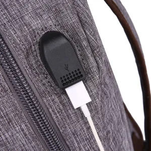 Water-resistant grey school backpack with external USB charging port and durable zipper closure.