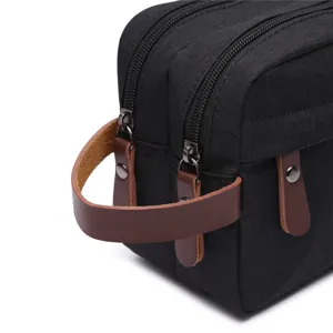 Borsa da toeletta impermeabile nera con manico in pelle e doppia cerniera per cosmetici.