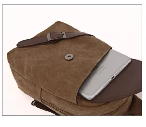 Canvas chest bag detail view showing tablet pocket compartment and leather buckle design.