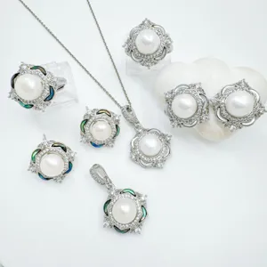 Exquisite pearl jewelry set detail showing necklace rings and earrings with abalone shell.