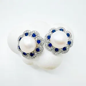 Exquisite Perlen Ohrstecker mit blauen Edelsteinen und funkelnden Strassdetails.