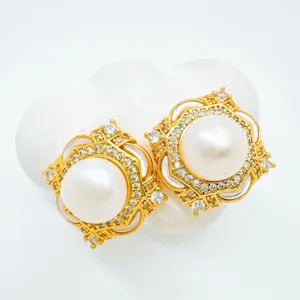 Elegant gold pearl stud earrings with sparkling rhinestones and white shell details.