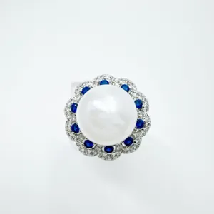 Eleganter Perlen Cluster Ring mit blauem Edelstein Halo und funkelnden Zirkon Details