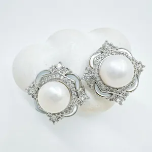 Luxurious silver pearl stud earrings with sparkling micro-pave diamonds and clover design.